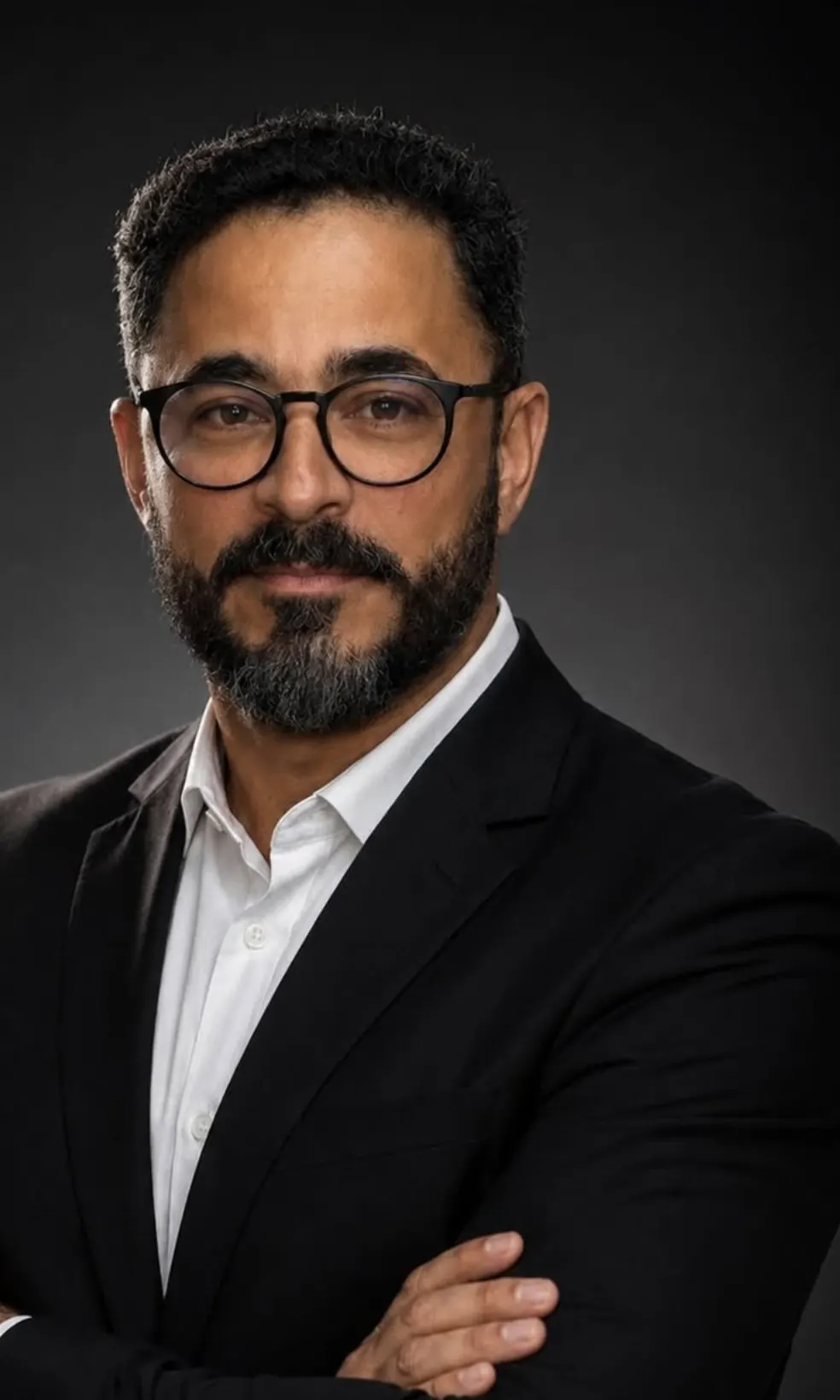 Retrato de Adryano Titara, de óculos, camisa branca e terno escuro